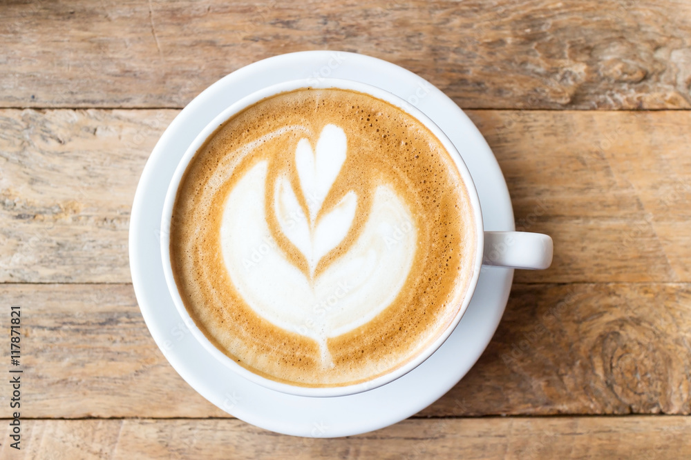 Cup of coffee with heart pattern in a white cup on wooden backgr Cup of coffee with heart pattern in a white cup on wooden backgr