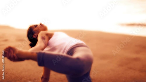 woman practices yoga at the beach photo