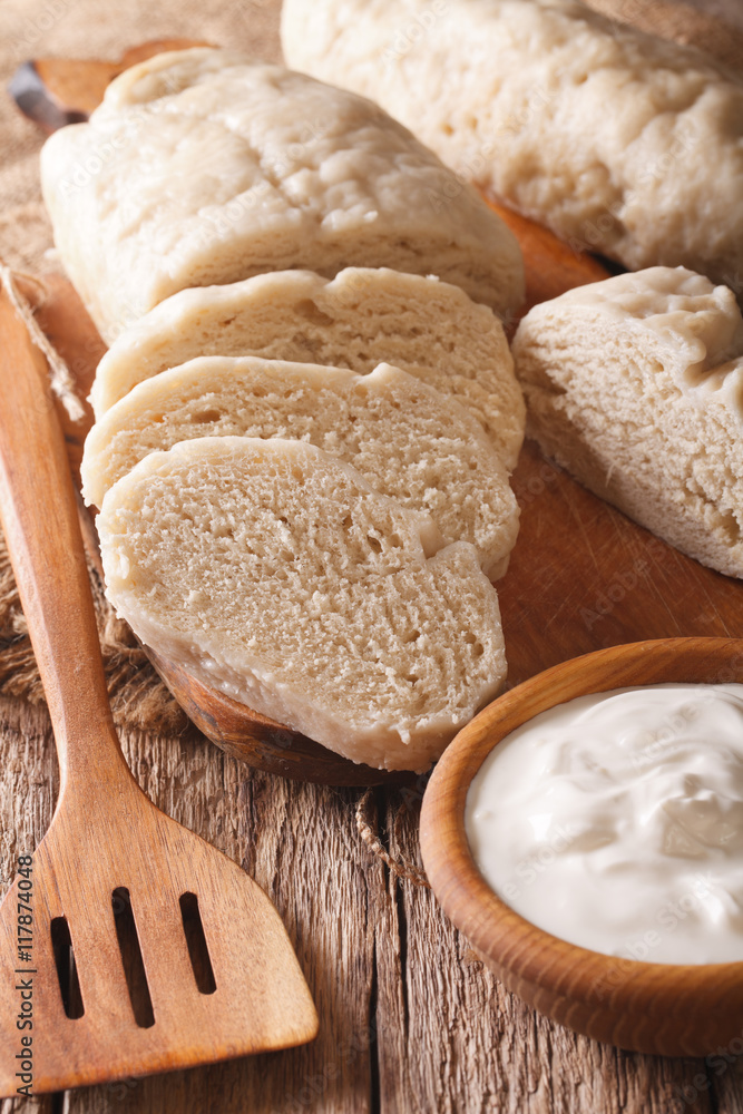 sliced boiled knedle close-up and sour cream. Vertical
sliced boiled knedle close-up and sour cream. Vertical