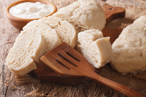 Fresh sliced yeast knedliks and sour cream close-up. horizontal
 photo