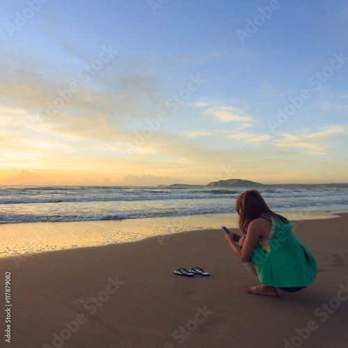 woman travel enjoy take a photo on the beach with sunrise