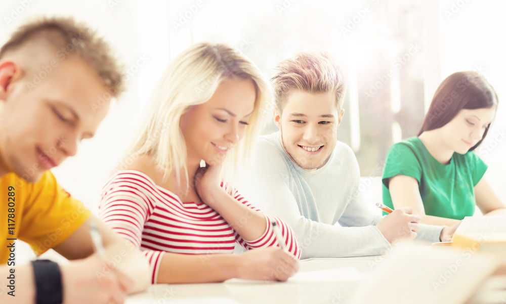 Group of teenage students studying at the lesson Group of teenage students studying at the lesson
