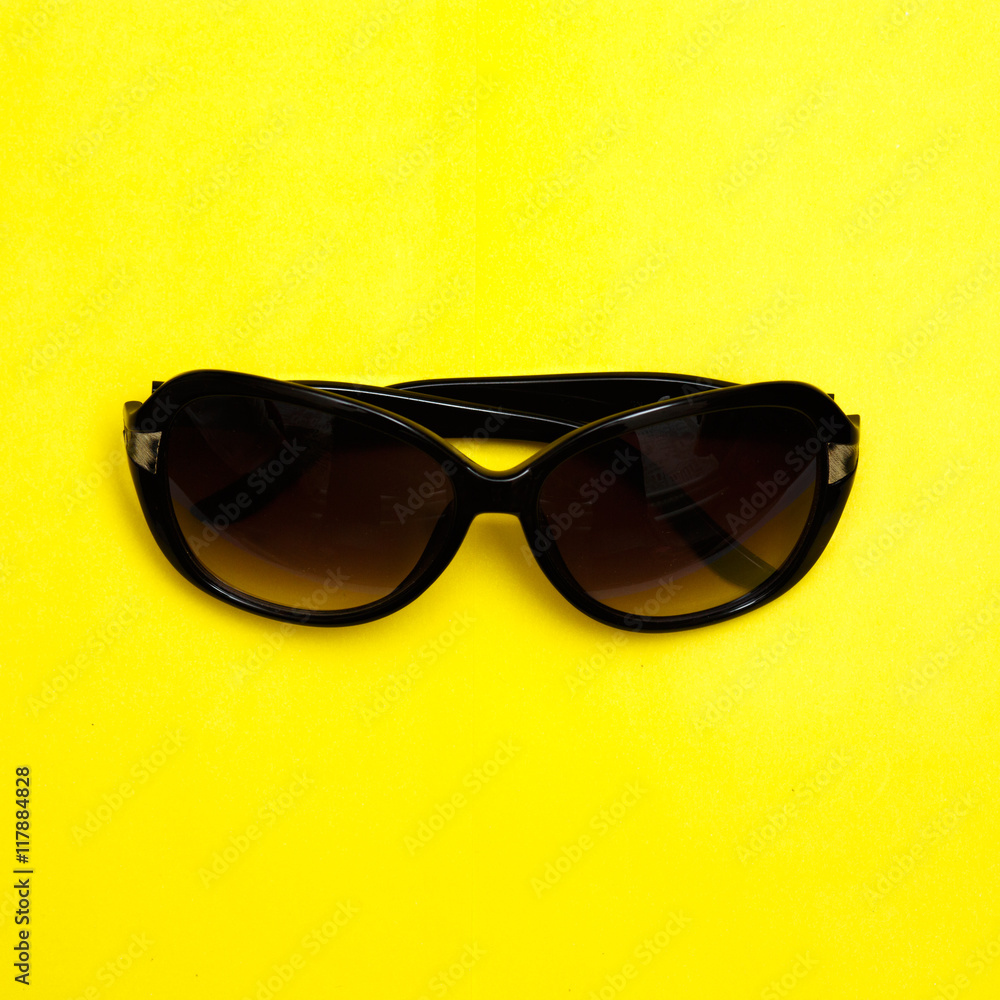 Stylish sunglasses on yellow background. fashion top view flat lay