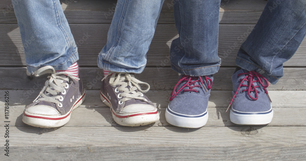 Boys feets with sneakers. Children sitting on the stairs. Outdoor