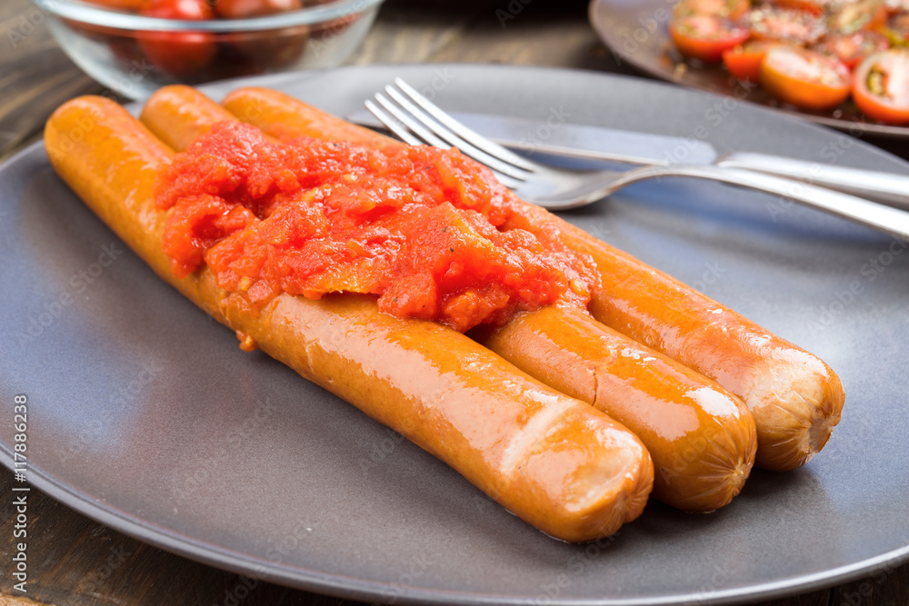 Whole frankfurters, stewed with tomatoes in clay dish Whole frankfurters, stewed with tomatoes in clay dish