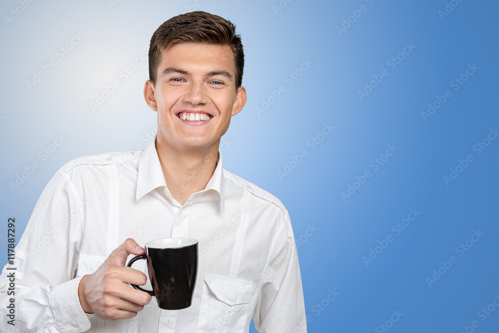 Young man holding warm cup of tea/coffee Young man holding warm cup of tea/coffee