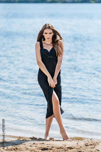 Woman in long black dress on a beach