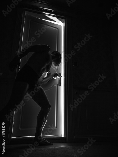 Man peeping through the door at night