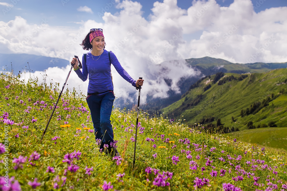 A woman hiking through the mountain alpine meadows in Caucasus mountains, Abkhazia