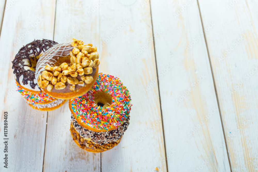 Collection of tasty donuts on white wooden board Collection of tasty donuts on white wooden board