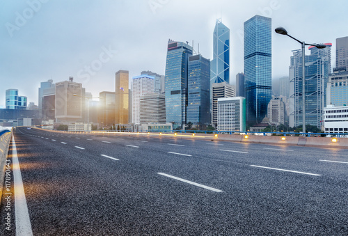 city empty traffic road with cityscape in background photo