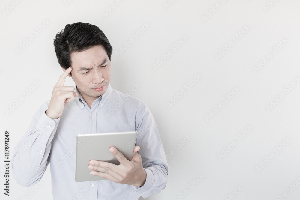 Serious young male executive using digital tablet against Serious young male executive using digital tablet against