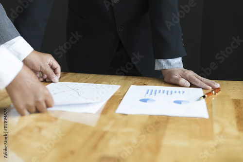 businessman in suit discuss with market analysis business chart