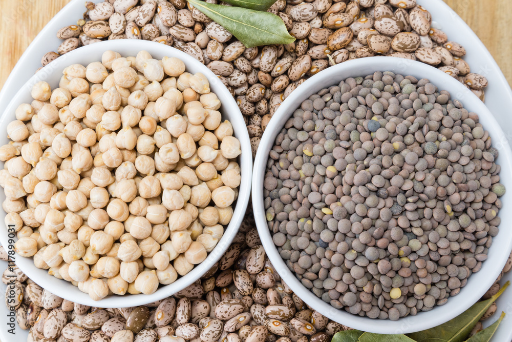 beans, chickpeas and lentils in porcelain bowls on a wooden table
beans, chickpeas and lentils in porcelain bowls on a wooden table