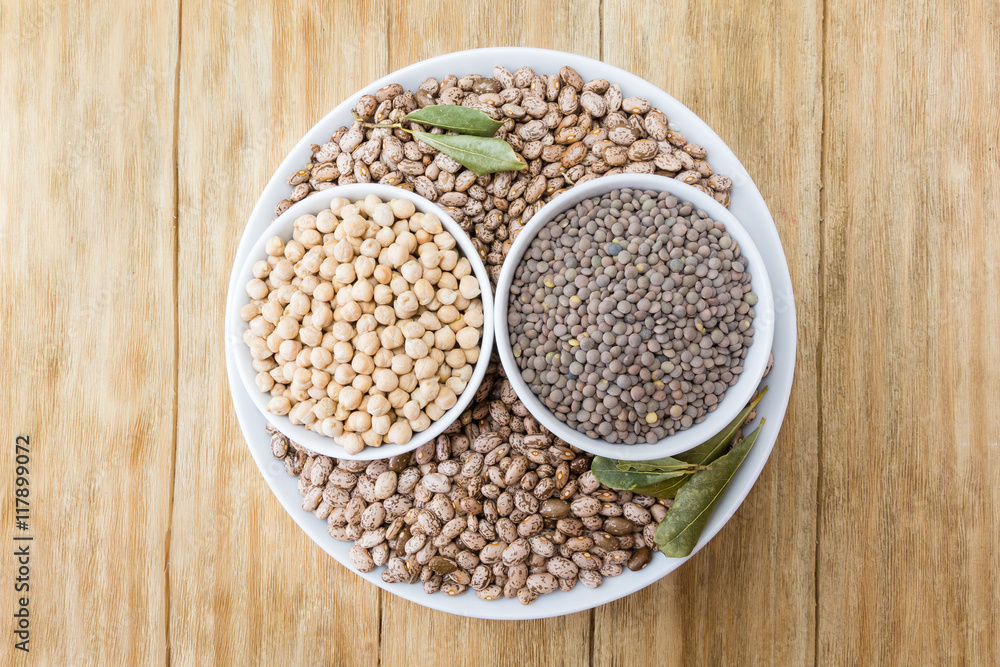 beans, chickpeas and lentils in porcelain bowls on a wooden table
beans, chickpeas and lentils in porcelain bowls on a wooden table
