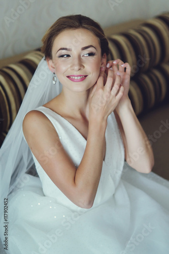 Portrait of the beautiful bride against a window indoors