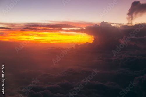 Lurid sky with clouds during sunrise. Air travel plane. Soft focus