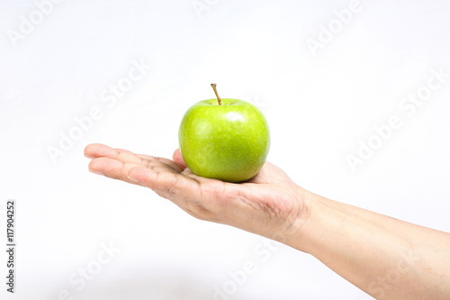 Green apple held on hand finger