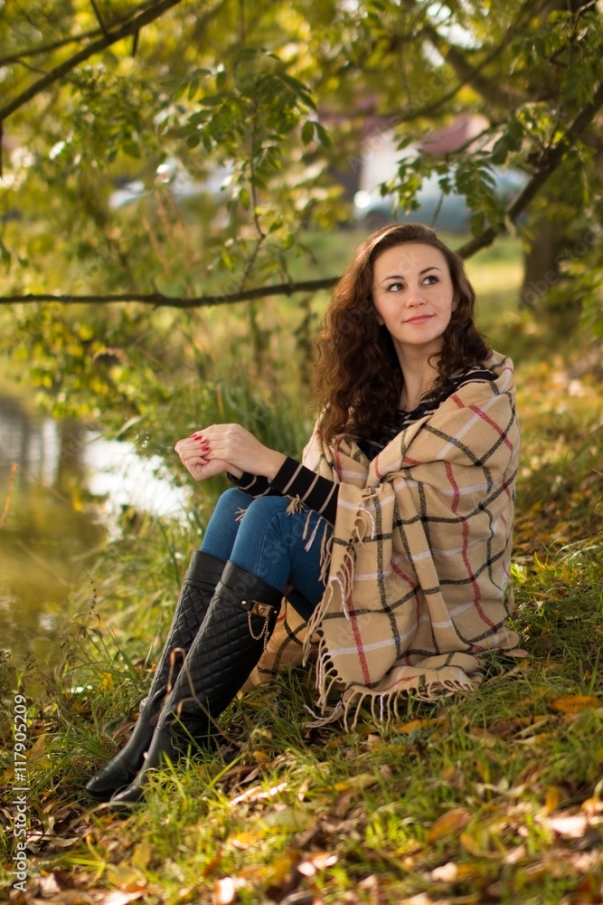 Young woman with blanket in the park in the autumn Young woman with blanket in the park in the autumn