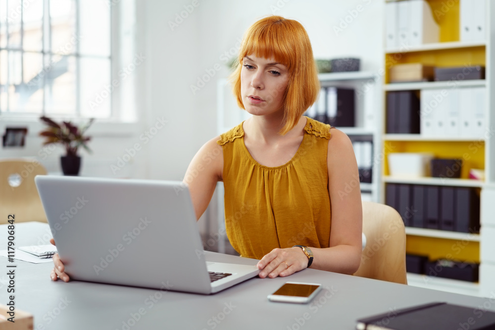 frau sitzt im büro und schreibt konzentriert am laptop frau sitzt im büro und schreibt konzentriert am laptop