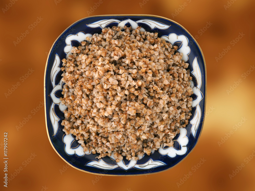 Beautiful dish with buckwheat on a gold background. View from above Beautiful dish with buckwheat on a gold background. View from above