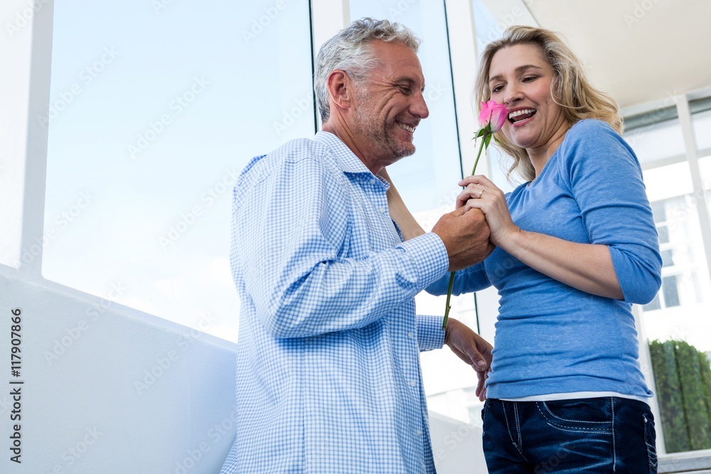 Fototapeta premium Happy man giving rose to woman