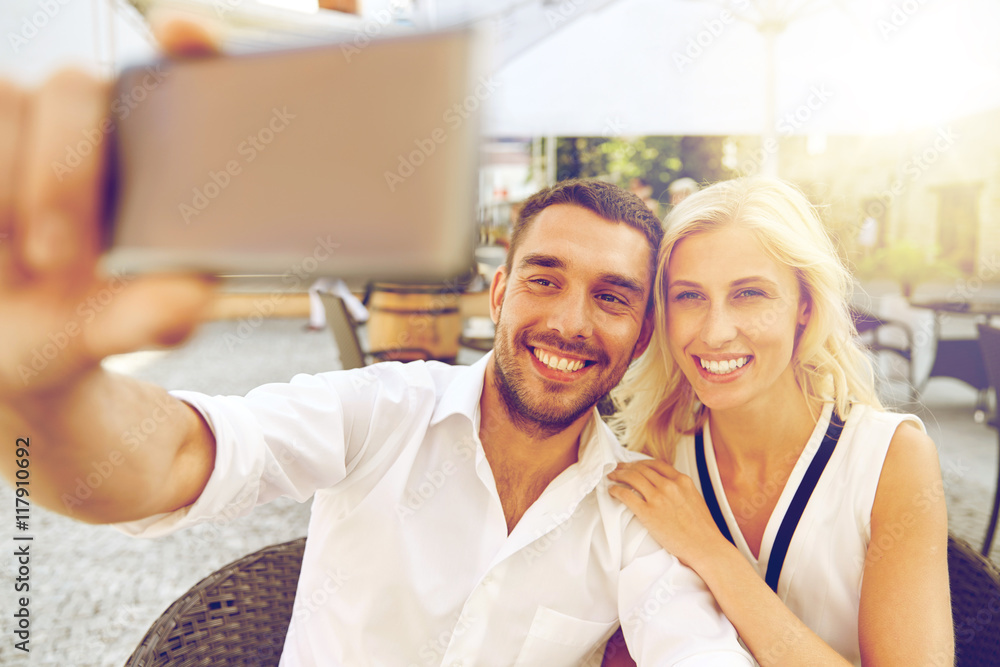 couple taking selfie with smatphone at restaurant couple taking selfie with smatphone at restaurant