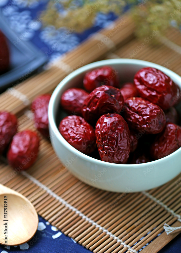 A bowl of red dates on spread a blue cloth on the desktop A bowl of red dates on spread a blue cloth on the desktop
