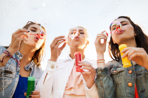 young women or girls blowing bubbles outdoors