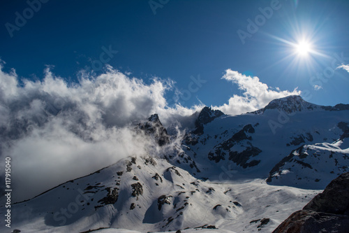 Views out from the Albert Heim Hutte Switzerland as the clouds pass and the sun beams down on the snow covered mountains © dchapman93