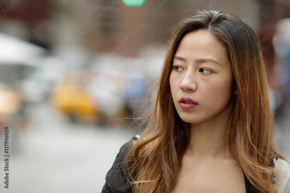 Young Asian woman in city serious face portrait Young Asian woman in city serious face portrait