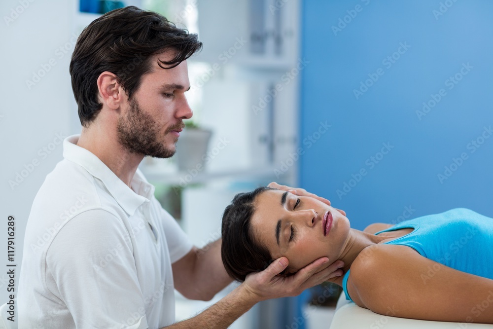 Male physiotherapist giving head massage to female patient Male physiotherapist giving head massage to female patient