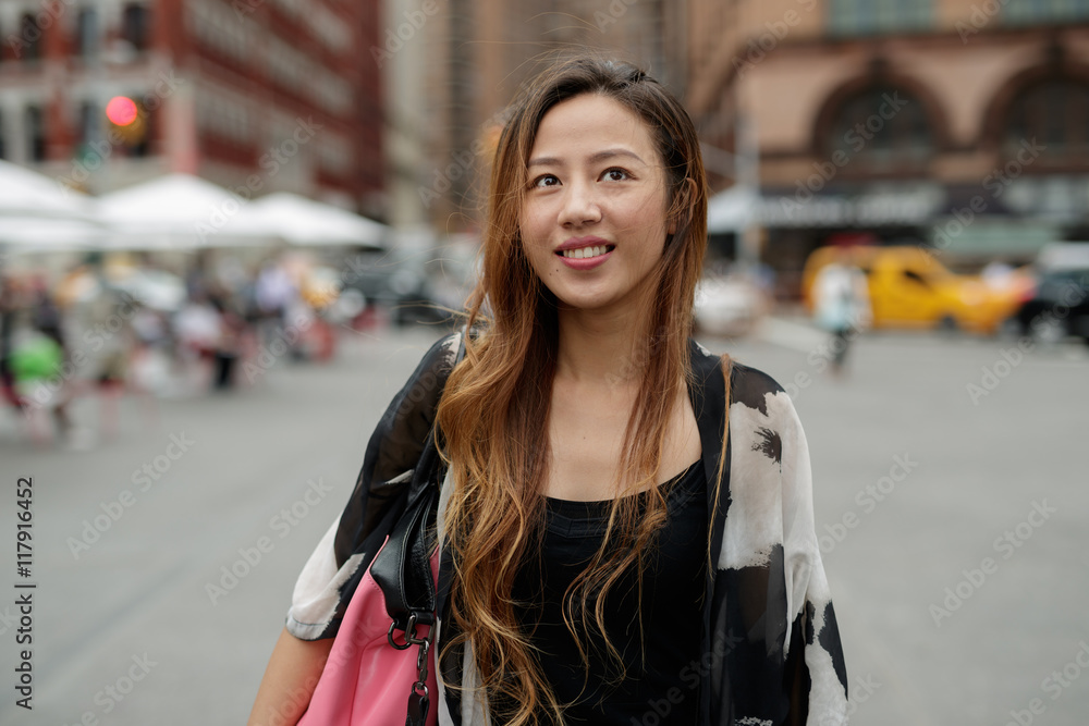 Young Asian woman in city walking smile happy face
Young Asian woman in city walking smile happy face