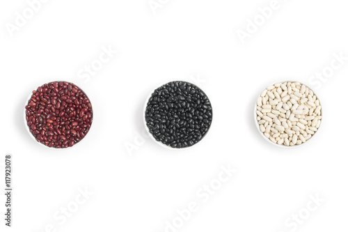 Raw Black, Red and White beans into a bowl in white background.