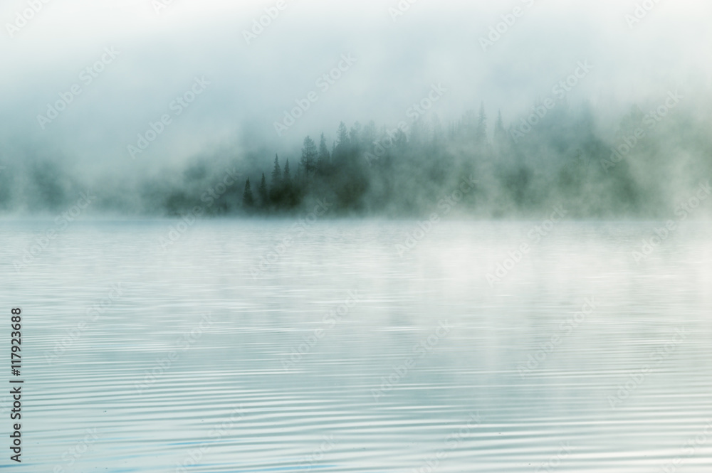 Fototapeta premium Heavy fog in the early morning on a mountain lake Early morning on Yazevoe lake in Altai mountains, Kazakhstan 