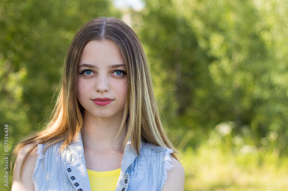 Horizontal portrait of a teenage girl with blond hair, big blue eyes and colorful lips dressed in denim jacket Horizontal portrait of a teenage girl with blond hair, big blue eyes and colorful lips dressed in denim jacket