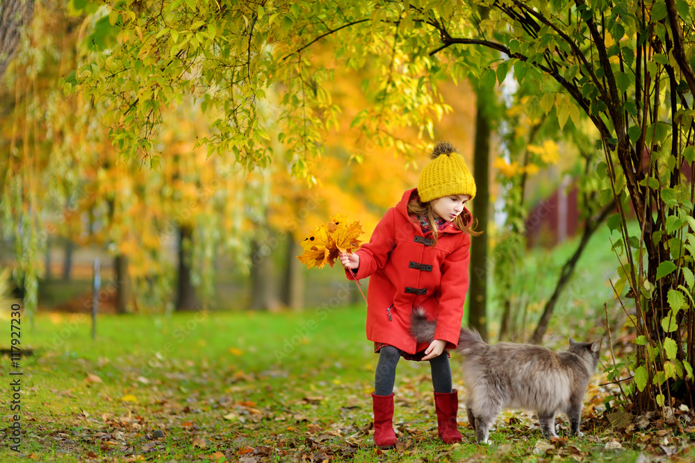Portrait of a cute little girl and her pet cat on beautiful autumn day Portrait of a cute little girl and her pet cat on beautiful autumn day