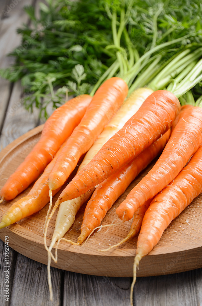 Bunch of fresh carrot on wooden background, selective focus Bunch of fresh carrot on wooden background, selective focus