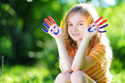 Adorable little girl with her hands painted having fun outdoors
