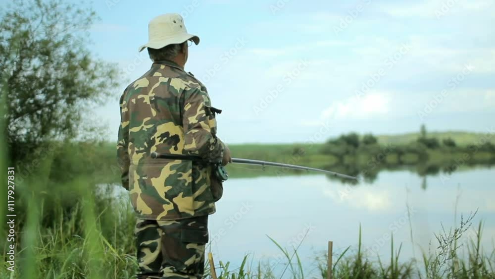 Fisher man with fishing rod catching fish on lake Fisher man with fishing rod catching fish on lake