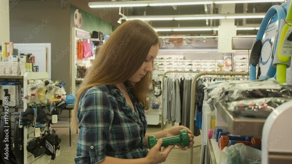Young pretty girl is choosing clothes in store in the shopping mall Young pretty girl is choosing clothes in store in the shopping mall