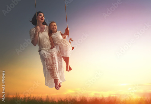 mother and daughter swinging on swings