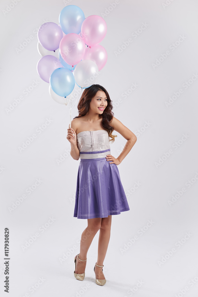 Full-length portrait of Vietnamese young lady with many colorful balloons