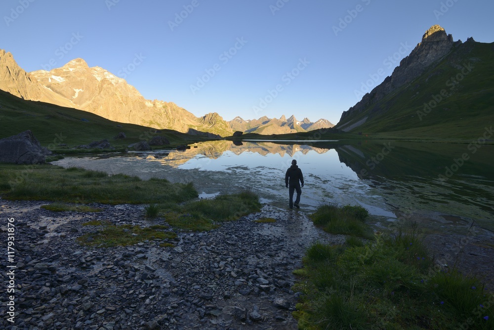 A lone hiker in the Alps, Cerces lake, Savoy, France A lone hiker in the Alps, Cerces lake, Savoy, France