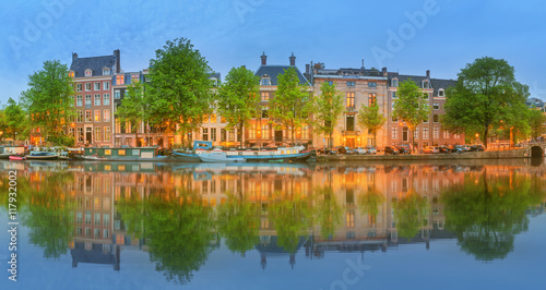 Panoramic view and cityscape of Amsterdam with boats, old buildings and Amstel river, Holland, Netherlands