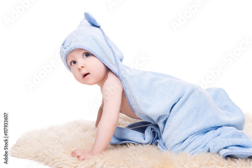 funny baby in blue cape with hood crawling and looking into the camera with surprised, isolated on white