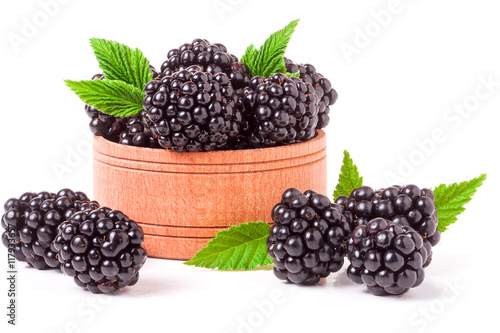 Blackberries with leaves in a wooden bowl isolated on white background