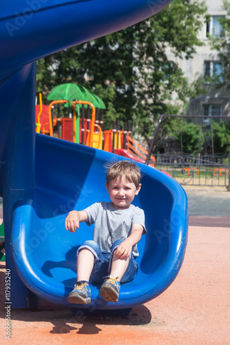 Four-year child riding a roller coaster at the playground