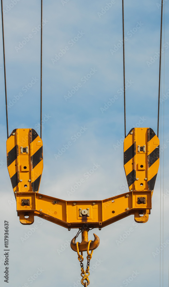 Bright orange tower crane against of blue sky , hook detail, construction concept Bright orange tower crane against of blue sky , hook detail, construction concept