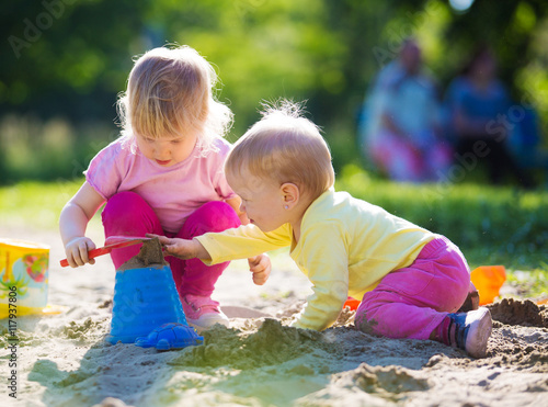 Two children playing in sandbox photo